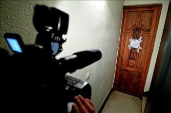  Un cámara de televisión toma imágenes de la puerta precintada del piso de la calle de Ciscar de Valencia donde a última hora de ayer fue encontrada muerta una mujer. (Foto: MANUEL BRUQUE)