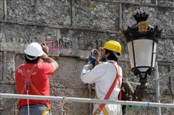 Dos trabajadores de una empresa privada se disponen a retirar el nombre de José Antonio Primo de Rivera de la fachada de la iglesia de San Miguel de Bouzas en Vigo. (Foto: SALVADOR SAS)