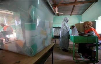 Una mujer coge una papeleta en un colegio electoral en Omdurman (Sudán). (Foto: EFE)