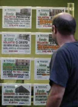 Un hombre consulta varios carteles de alquileres.