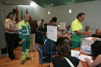 Un funcionario entrega su voto y otros aguardan para hacerlo. (Foto: Marcos Atrio.)