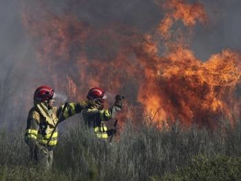 Dos operarios controla un fuego declrado el pasado mes de marzo en Cualedro. (Foto: XESÚS FARIÑAS)