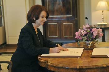 Guillard, firmando el acta de su nombramiento como primera ministra de Australia. (Foto: Alan Porritt)