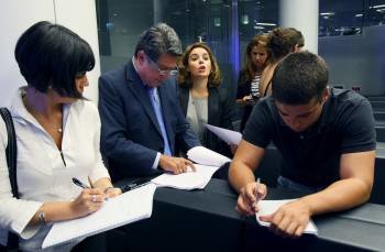 Los dirigentes del PP, Federico Trillo y Soraya Sáenz leen con varios periodistas el contenido de la sentencia.