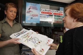 Una vendedora entrega el extra de La Región, junto con el periódico, a una clienta, en Carballiño. (Foto: Xesús Fariñas)