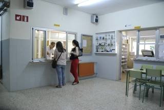 Dos jóvenes realizan una consulta en la oficina de Secretaría del Instituto Lauro Olmo