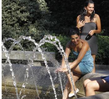 Una joven moja sus manos en el Parque de San Lázaro. Su amiga bromea con su acción. (Foto: Fariñas)