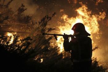  Un miembro de una brigada de lucha contra incendios lucha esta madrugada contra el fuego forestal declarado en la localidad de Fornelos de Montes.
