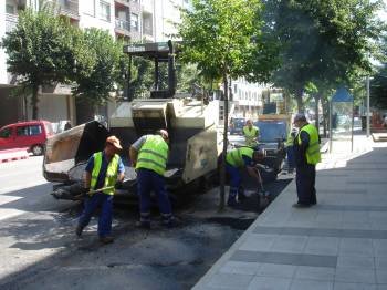 Un grupo de trabajadores asfaltan una franja de la avenida Conde de Fenosa.