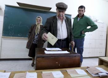 Un hombre introduce su voto en una urna. (Foto: T. Bozoglu)