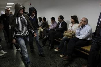 Dos de los acusados, con capucha, y  a la derecha la víctima del asalto, Manuel Fernández Blanco. (Foto: Miguel Angel)