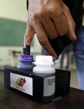 Un votante, con su dedo bañado en tinta indeleble. (Foto: David Fernández)