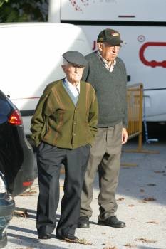 Dos mayores pasean por una plaza.