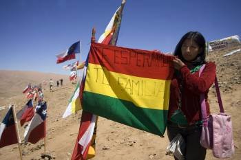 La mujer del minero boliviano atrapado sostiene la bandera de su país con un mensaje para su marido. (Foto: Danny Alveal)