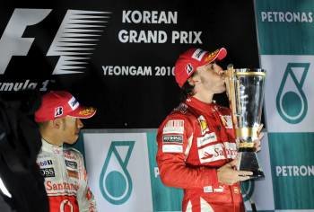 Hamilton observa como Alonso besa la copa en lo alto del podio en Corea.