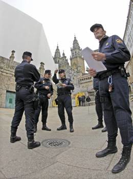 Un grupo de policías prepara el despliegue en el Obradoiro. (Foto: Lavandeira jr)