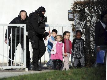 Dos policías acompañan a cuatro de los niños retenidos. (Foto: Trias Philippe)