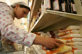 La empleada de un supermercado de Xinzo repone paquetes de azúcar. (Foto: Marcos Atrio)
