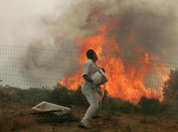 Un hombre lucha contra el fuego con un cubo. (Foto: ARCHIVO)