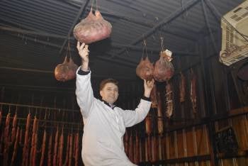 José Pérez sujeta dos de los botelos elaborados en 'Carnes y Embutidos Valdeorras', en Viloira. (Foto: LUIS BLANCO)