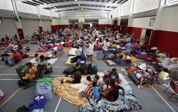 Personas evacuadas descansan en un complejo deportivo de Cairns. (Foto: COLYN HUBER)