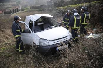 Los bomberos analizan el estado en el que quedó el vehículo siniestrado ayer en Grixó. (Foto: MARTIÑO PINAL)