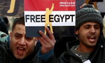 Varios egipcios protestan en contra del presidente egipcio durante las protestas a favor de su dimisión en la embajada egipcia en Seúl (Corea del Sur) hoy, viernes. 