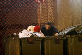 Dos hombres rebuscan entre los contenedores de la basura durante la noche. (Foto: MIGUEL ÁNGEL)
