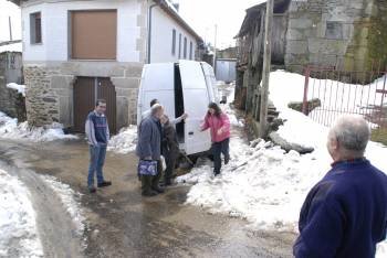 Unos vecinos de Ramilo intentan abrir paso a una furgoneta entre la nieve. (Foto: L.B.)