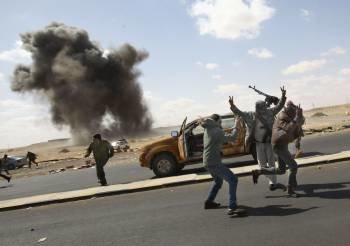 Rebeldes libios huyen de los bombardeos de la aviación leal a Gadafi. (Foto: KIM LUDBROOK)