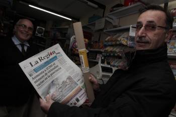 Un cliente muestra el periódico junto a la lámina adquirida.  (Foto: XESÚS FARIÑAS)