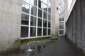 Una manguera saca el agua procedente del sótano de la Casa da Cultura. (Foto: MARTIÑO PINAL)