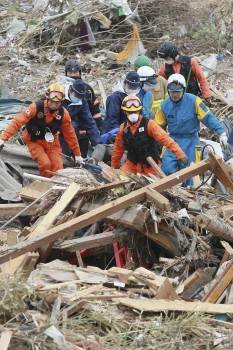 Miembros de los equipos de rescate recuperan un cadáver en la ciudad de Sendai. (Foto: YONHAP)