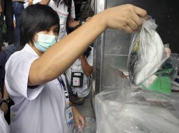 Una funcionaria tailandesa toma muestras de pescado importado de Japón. (Foto: R. YONGRIT)