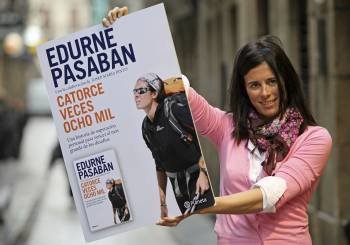 Edurne Pasaban, la primera mujer que ha conquistado las catorce cumbres más altas del planeta, posa con un cartel con la portada de su libro 'Catorce veces ocho mil'.