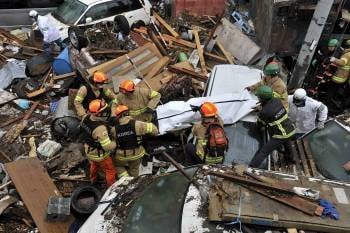 Los bomberos coreanos consiguen rescatar un cuerpo entre las ruínas de sendai. (Foto: )