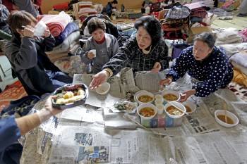 Un grupo de refugiados recibe raciones de comida en la ciudad costera de Rikuzentakata. (Foto: DAI KUROKAWA)