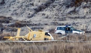 Un vehículo de la Guardia Civil, junto al helicóptero accidentado en Teruel. (Foto: PEDRO ETURA)