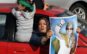 Una mujer muestra una imagen de Gadafi durante una manifestación pro-gubernamental en Trípoli. (Foto: MOHAMED MESSARA)