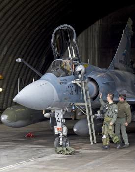 Un piloto y un técnico junto a un avión Mirage 2000-5, en la base de Dijón, antes de partir hacia Libia. (Foto: ANTHONY JEULAND)