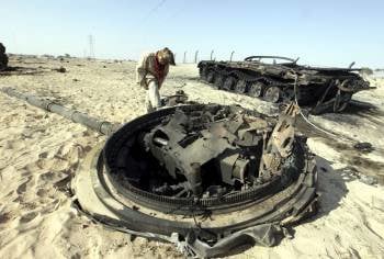 Un rebelde libio junto a un tanque destruido cerca del acceso oriental a Ajdabiya. (Foto: K.ELFIQUI)