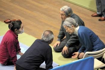 El emperador Akihito (d-i) y su esposa Michiko (d-d) conversan con una pareja en un centro para evacuados en Tokio, Japón.