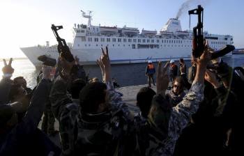 Un grupo de rebeldes saluda la llegada a Bengasi del ferry turco. (Foto: M.GAMBARINI)
