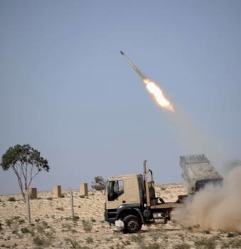 Rebeldes libios lanzan un misil contra las tropas de Gadafi que cercan Ajdabiya. (Foto: V. DONEV)