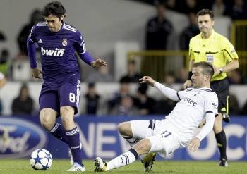 Kaká (i), supera la entrada del jugador holandés del Tottenham, Rafael van der Vaart. (Foto: Felipe Trueba)