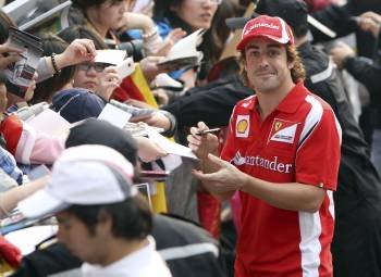 Fernando Alonso firma autógrafos a su llegada al circuito. (Foto: ADI WEDA)