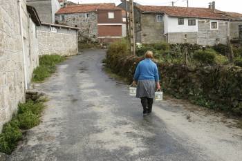 Una mujer camina por Baltar. El despoblamiento dificulta la financiación de los concellos. (Foto: MARTIÑO PINAL)