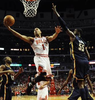 El jugador Derrick Rose (i) de los Bulls de Chicago encesta ante la defensa de Roy Hibbert de los Pacers de Indiana.
