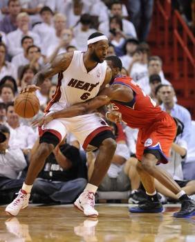 LeBron James de los Heat de Miami protege el balón de la marca de Louis Williams de los Sixers de Filadelfia. (Foto: RHONA WISE)