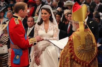 El príncipe Guillermo coloca, no sin ciertas dificultades, el anillo a Kate en presencia de Rowan Williams, primado de la Iglesia anglicana. (Foto: DOMINIC LIPINSK )